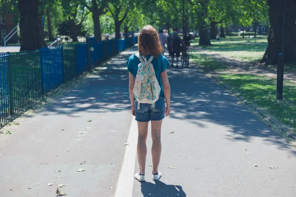 Young woman with backpack in park — Stock Photo, Image