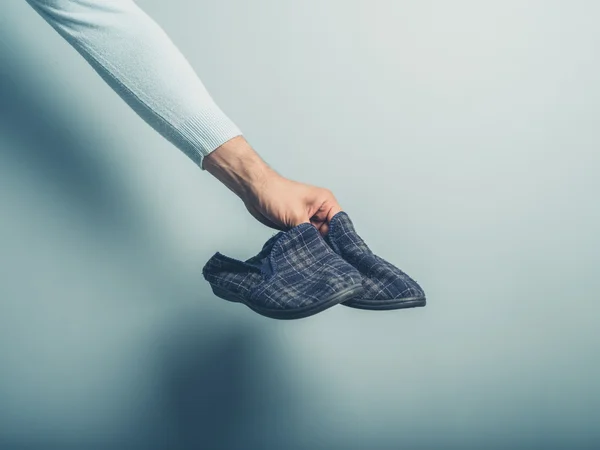 Hand holding slippers — Stock Photo, Image