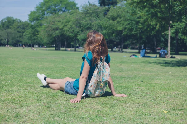 Jonge vrouw met rugzak ontspannen in park — Stockfoto
