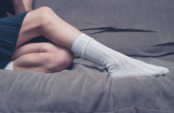 Mujer joven relajándose en un sofá — Foto de Stock