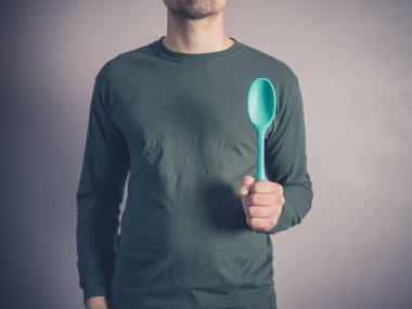 Genç adam bir lastik kaşık tutan