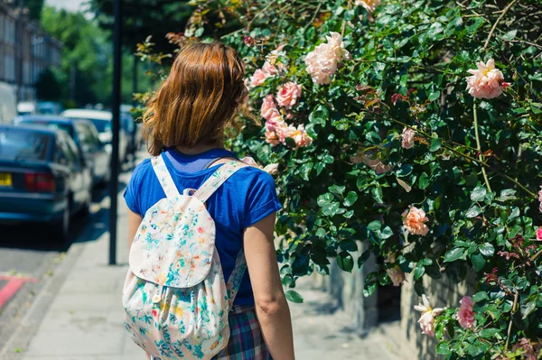 Mujer joven admirando rosal —  Fotos de Stock