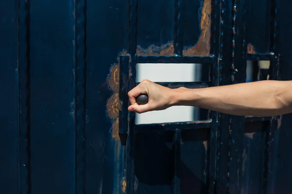 Main féminine ouvrant une porte — Photo