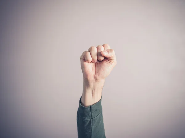 Clenched fist against purple background — Stock Photo, Image
