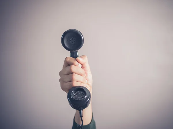 Hand of young man holding vintage phone — Stock Photo, Image