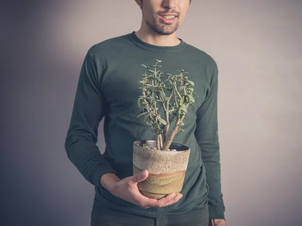 Jeune homme avec plante en pot — Photo