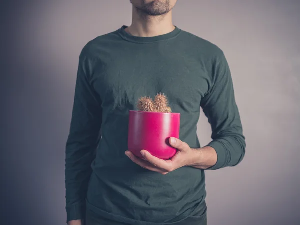 Giovane che tiene un cactus — Foto Stock