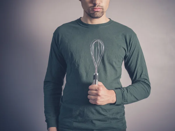 Young man holding a balloon whisk — Stock Photo, Image