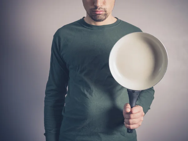 Молодий чоловік зі сковородою — стокове фото
