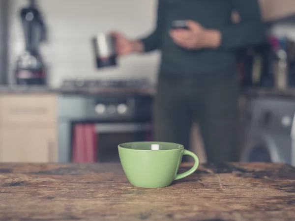 Kopje koffie in keuken met man in achtergrond — Stockfoto