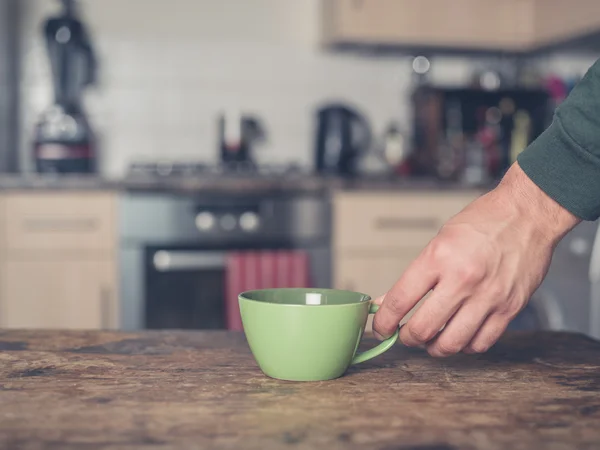 Colocar la taza a mano sobre la mesa — Foto de Stock