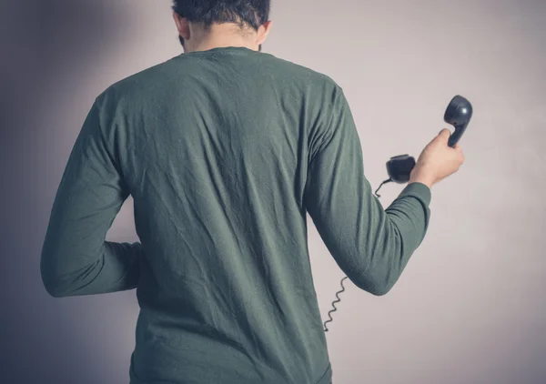 Rear view of man using rotary phone — Stock Photo, Image