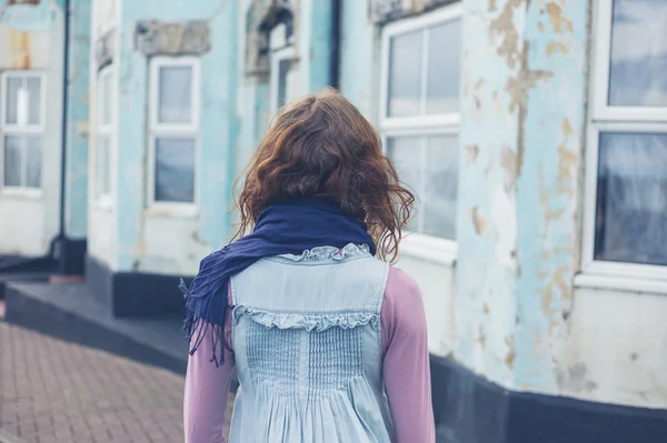 Mulher de pé na rua do lado de fora casa azul — Fotografia de Stock
