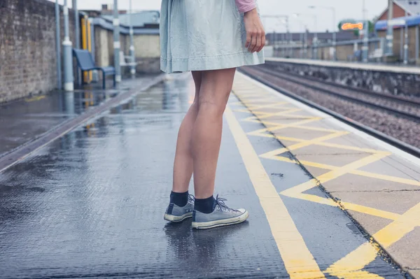 Legs of young woman standing on platform — Stock Photo, Image