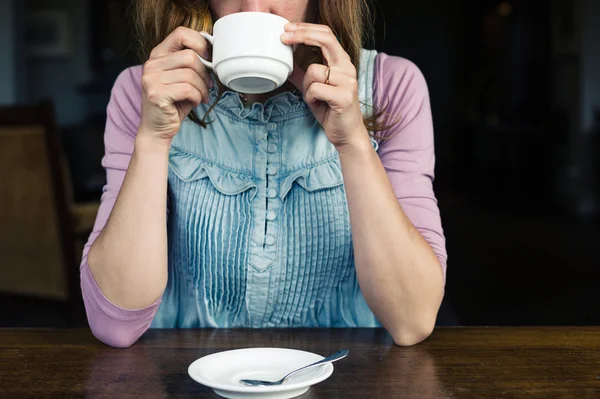 Женщина пьет чай или кофе — стоковое фото