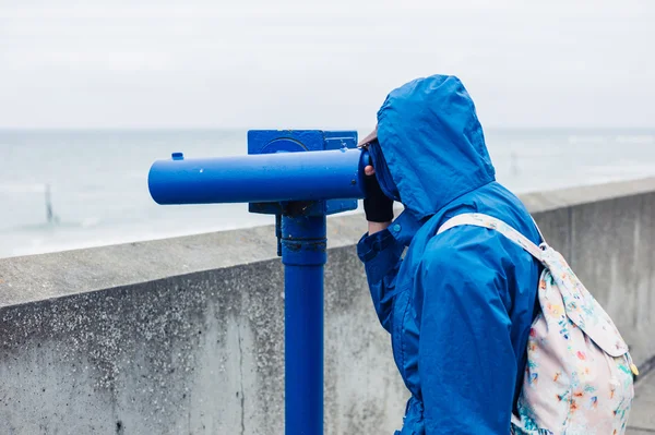 Pessoa que utiliza telescópio na costa — Fotografia de Stock