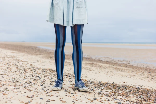 Jambes de jeune femme sur la plage — Photo