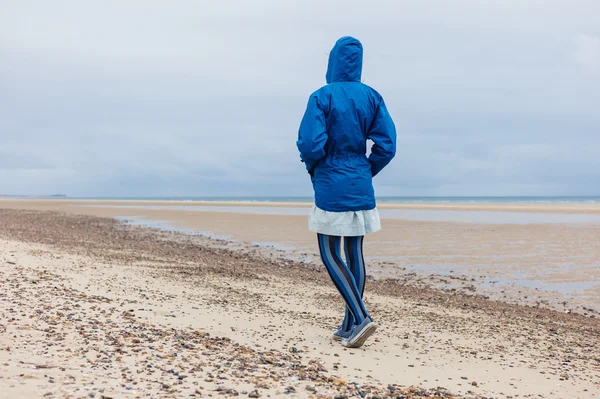 Ung kvinna promenader på stranden — Stockfoto