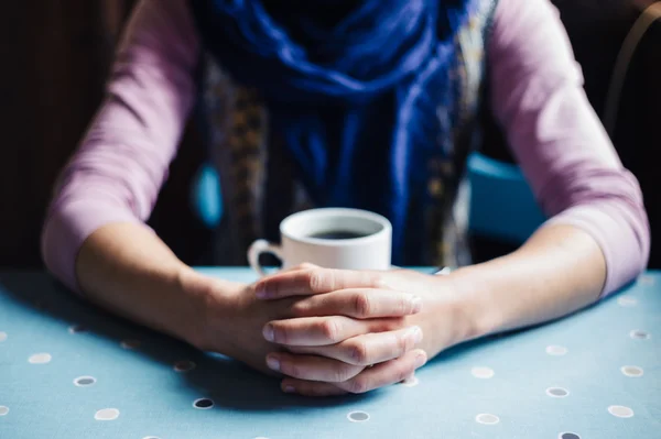 Молодая женщина со сложенными руками и кофе — стоковое фото