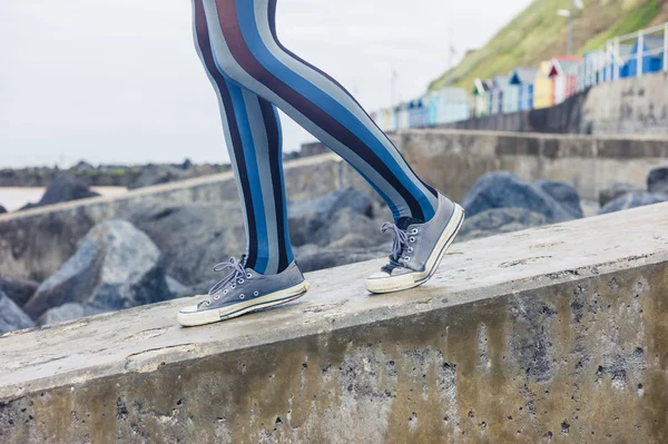 Jambes de femme marchant sur la côte — Photo