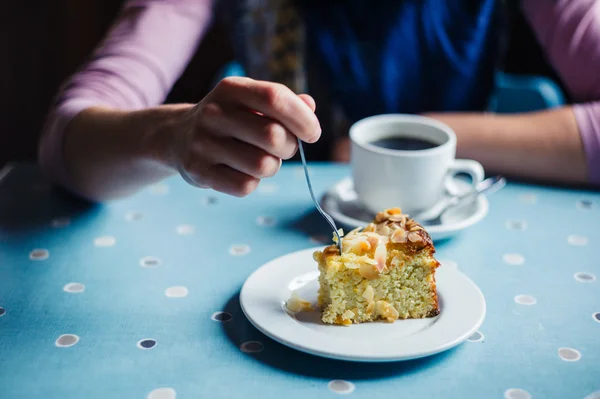 Mulher tomando café e bolo na sala de chá — Fotografia de Stock