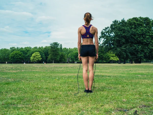 Woman in park exercising with jump rope — Stock Photo, Image