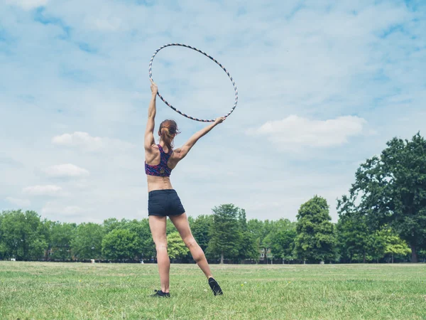 Vrouw in park met hoelahoep — Stockfoto