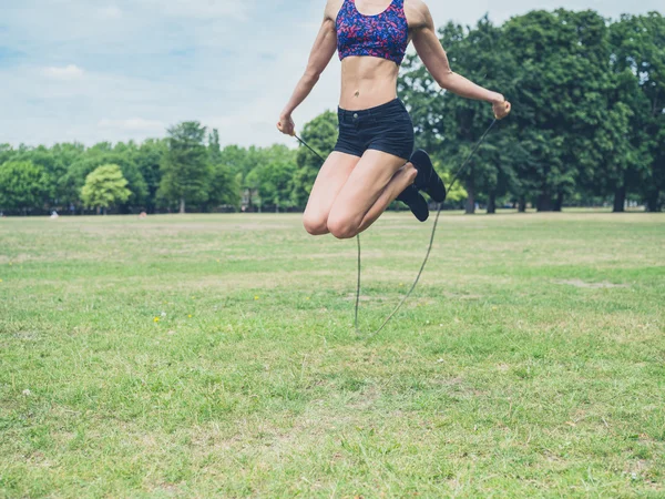 Mujer joven saltando en el parque —  Fotos de Stock