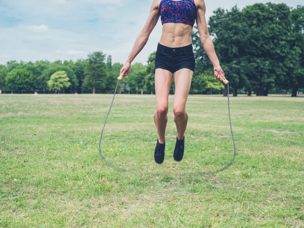Young woman skipping in the park — Stock Photo, Image