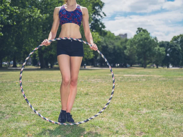 Fit vrouw in park met hoelahoep — Stockfoto