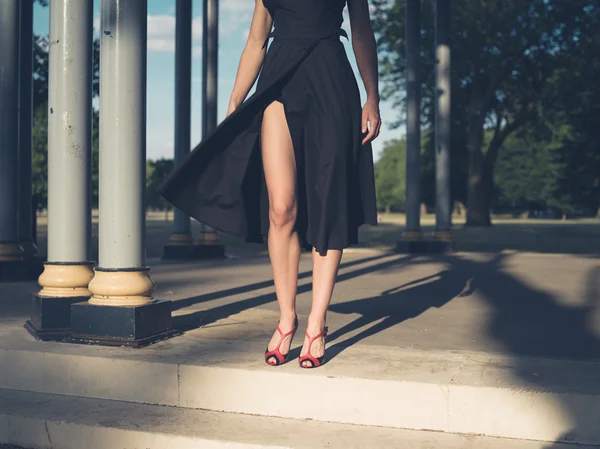 Elegant young woman in park at sunset — Stock Photo, Image