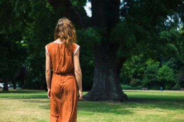 Genç kadın parkta ağaç bakarak