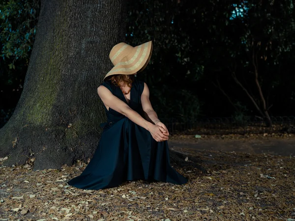 Elegante donna seduta sotto l'albero — Foto Stock