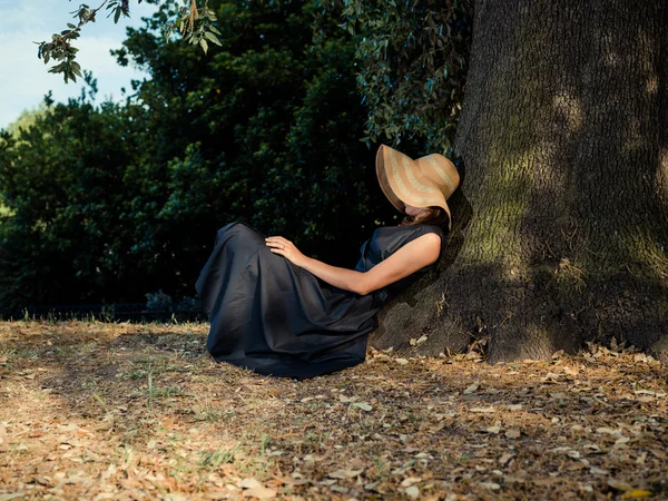 优雅的女人坐在树下 — 图库照片