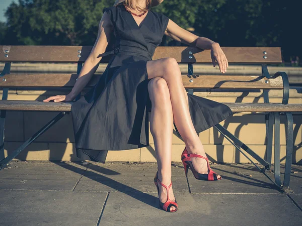 Élégante jeune femme assise sur le banc du parc — Photo