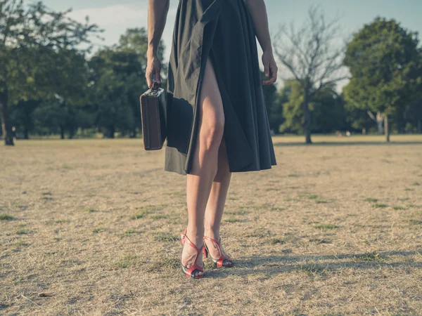 Young woman with briefcase in park — Stock Photo, Image