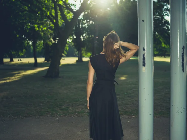 Frau, die bei Sonnenuntergang unter einem Bandständer steht — Stockfoto