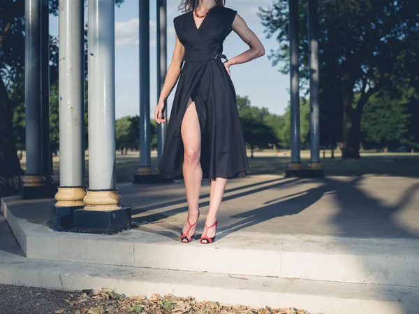 Elegancki młoda kobieta w parku na zachodzie słońca — Zdjęcie stockowe