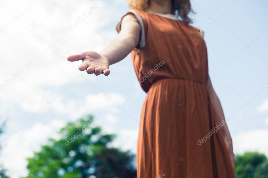 Young woman offering helping hand in nature