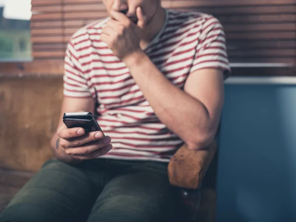 Jongeman die thuis een smartphone gebruikt — Stockfoto