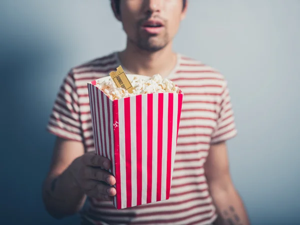 Jovem com pipoca e bilhete de cinema — Fotografia de Stock