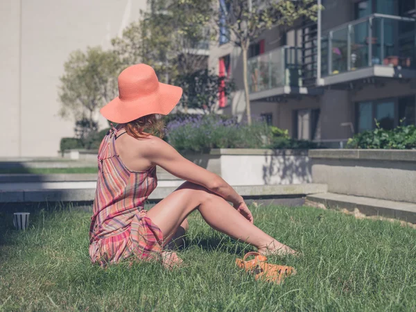 Young woman relaxing outside apartment block — Stock Photo, Image