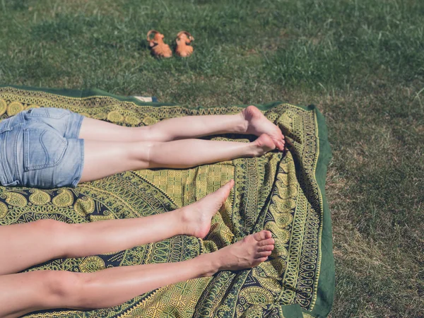 Jambes de deux jeunes femmes dehors sur l'herbe — Photo