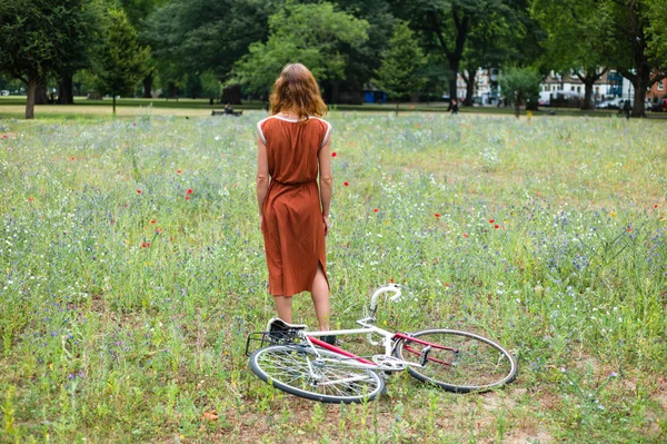 Mujer joven en el parque con bicicleta —  Fotos de Stock