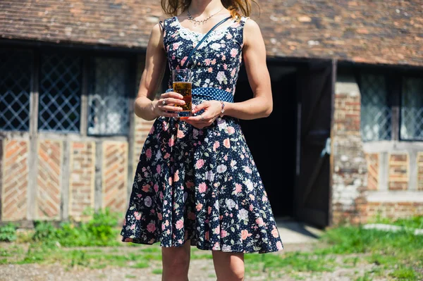 Jeune femme à l'extérieur de la maison de campagne avec boisson à la main — Photo