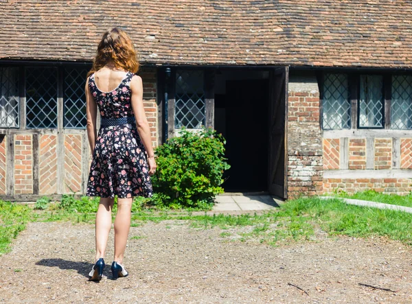 Jonge vrouw buiten landhuis — Stockfoto