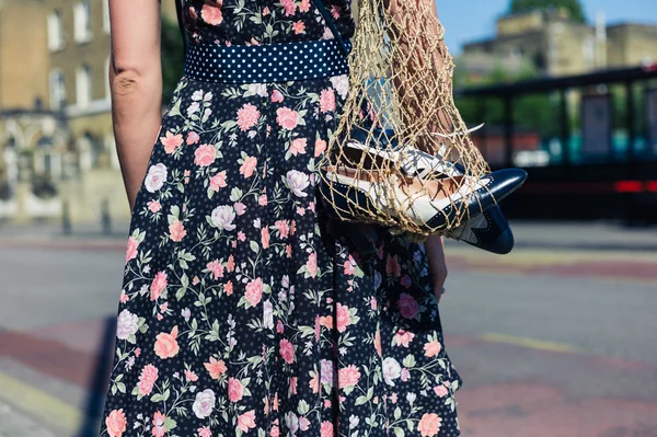 Young woman in street with spare shoes — Stock Photo, Image