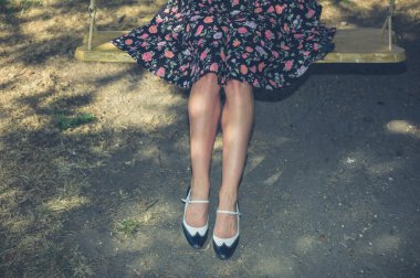 bir salıncak üzerinde oturan genç kadın 