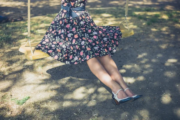 Jonge vrouw zitten op een schommel — Stockfoto