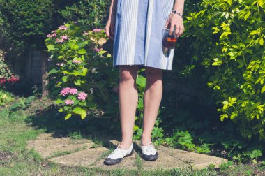 Bahçede duran genç bir kadın.